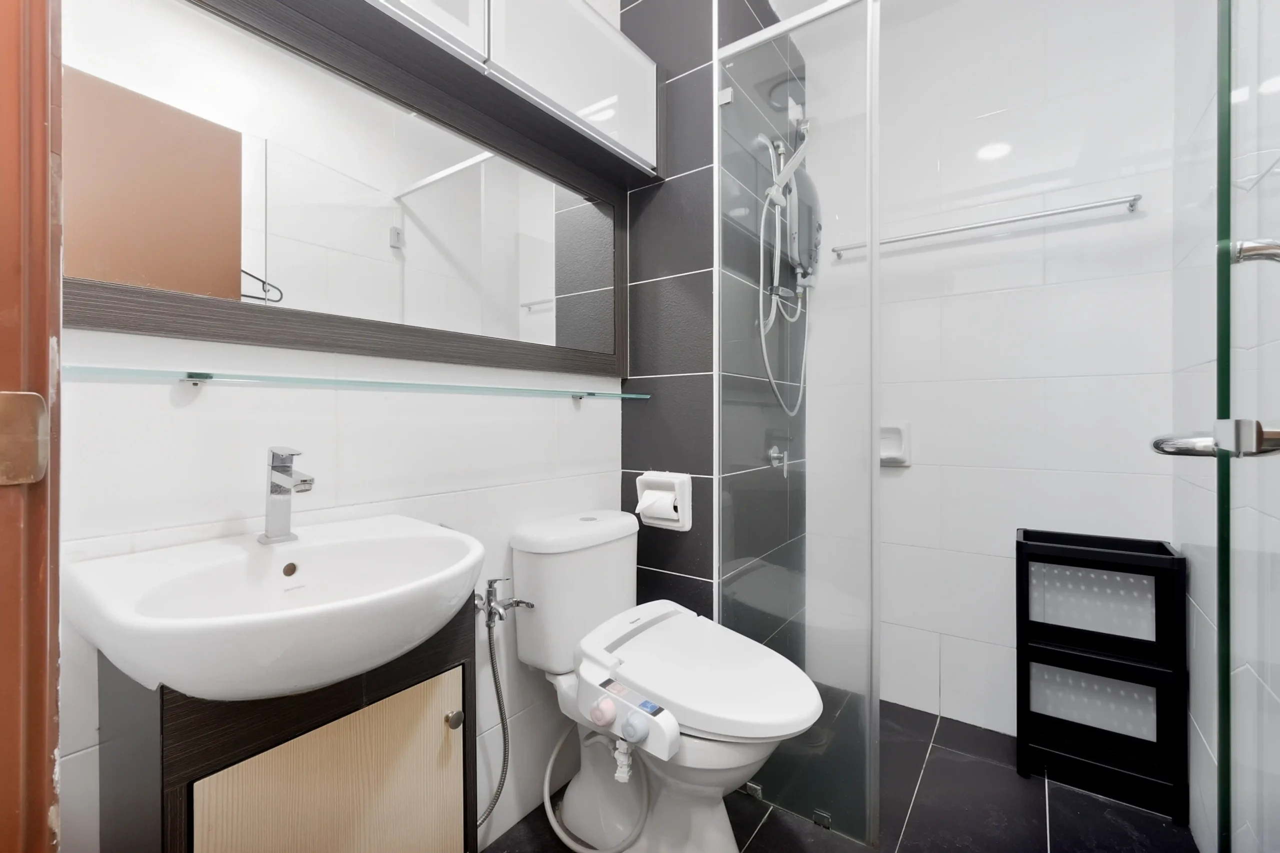 Clean bathroom with hot shower unit, fresh towels, shampoo, and shower gel