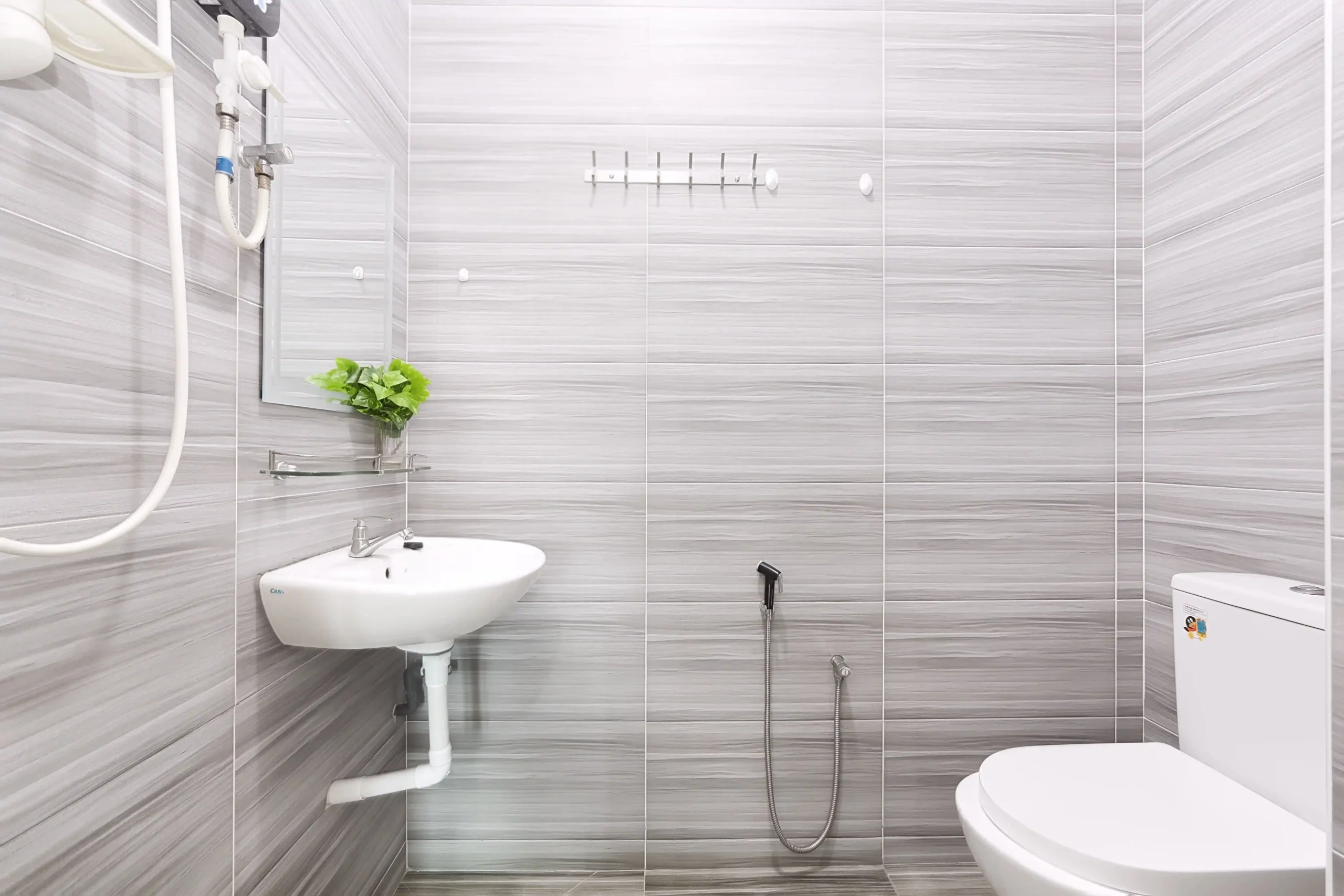 Clean combined shower and toilet bathroom with hot water in Ipoh homestay
